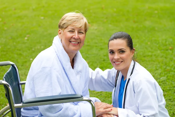 Cuidar médico amigável e paciente sênior feliz ao ar livre — Fotografia de Stock