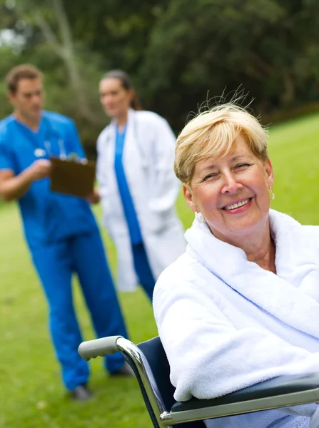 Hastane bahçesinde tekerlekli sandalye üzerinde oturan güzel kıdemli hasta — Stok fotoğraf