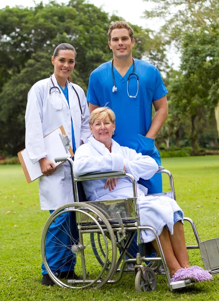 Ομαδική προσωπογραφία γιατρού, νοσηλευτή και ηλικιωμένου ασθενή στον κήπο του νοσοκομείου — Φωτογραφία Αρχείου
