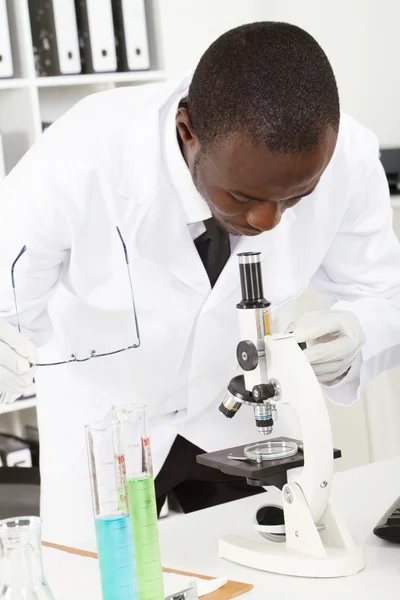 Lab researcher looking through microscope — Stock Photo, Image