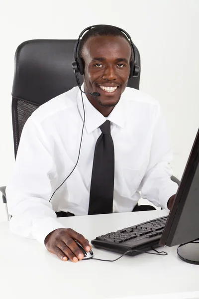 Empresario con auriculares sentado en el escritorio de la oficina — Foto de Stock