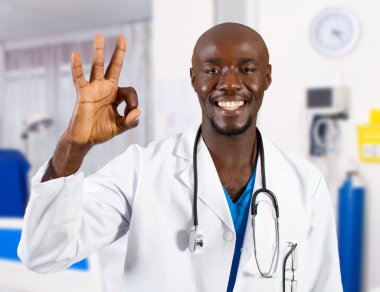 Happy african doctor giving OK hand sign clipart