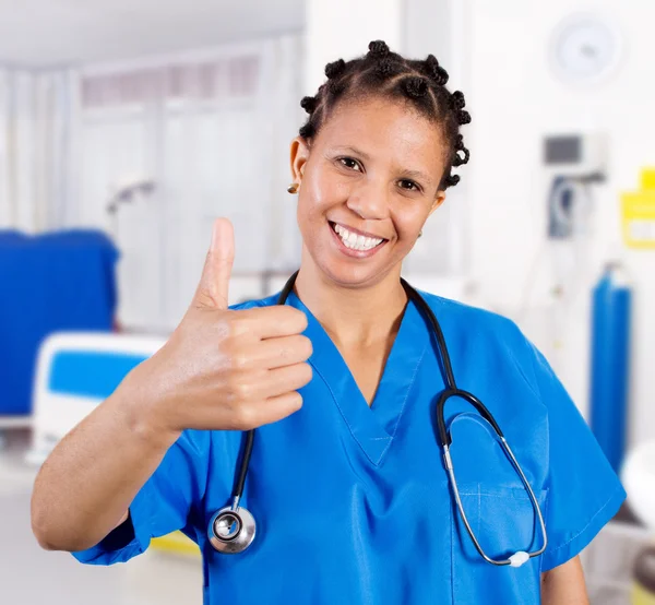 Jovem enfermeira afro-americana dando polegar para cima — Fotografia de Stock