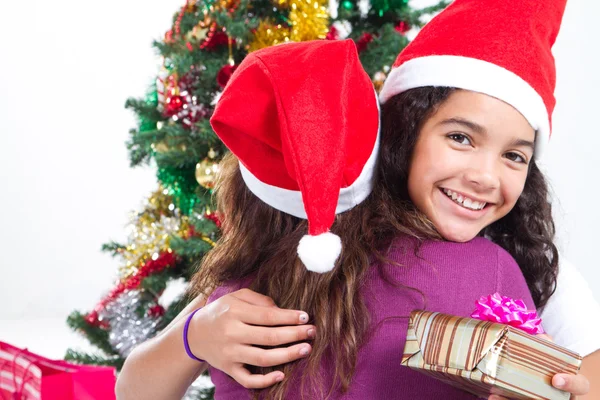 Söt tonåring tjej kramar mamma på juldagen — Stockfoto