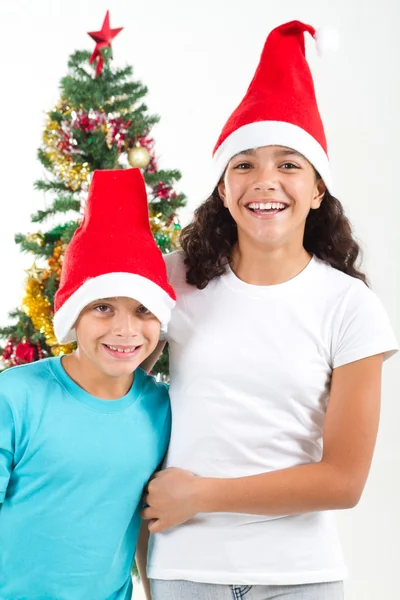 Irmã feliz e irmão na frente da árvore de Natal — Fotografia de Stock