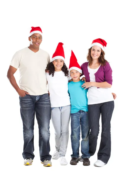 Rodina mnohonárodnostní čtyř nosí santa klobouky — Stock fotografie