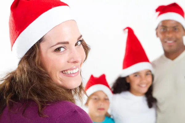 Vierköpfige multiethnische Familie trägt Weihnachtsmannmützen auf weißem Grund — Stockfoto