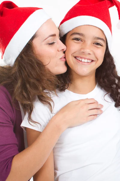 Jovem mãe beijando feliz filha no dia de Natal — Fotografia de Stock