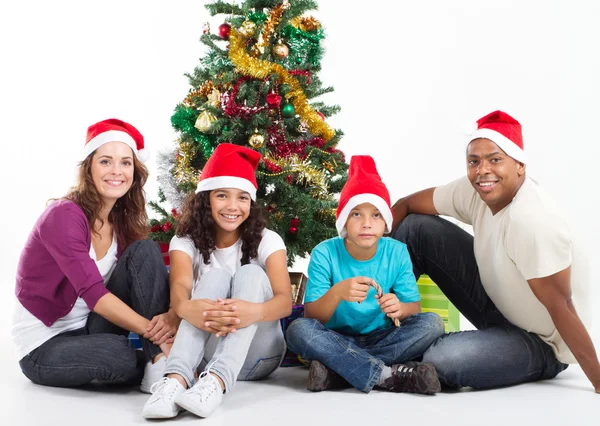Счастливая семья, сидящая рядом с елкой — стоковое фото