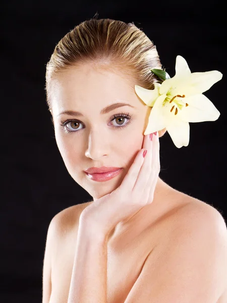 Attraktive junge Frau mit Blume auf schwarz — Stockfoto
