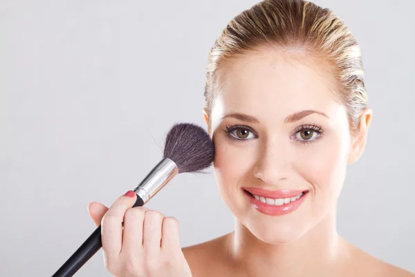 Bela mulher segurando escova de maquiagem sobre branco — Fotografia de Stock