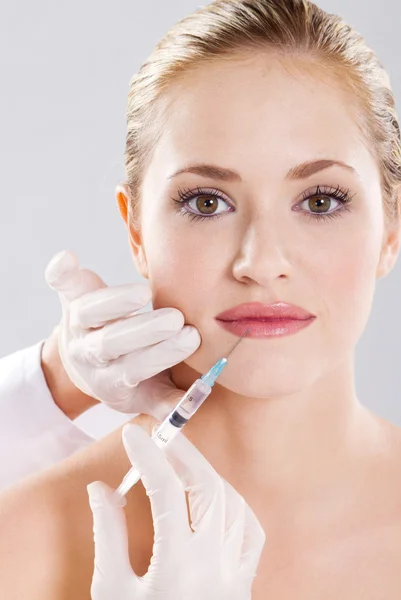 Kvinnan får en injektion i hennes läpp — Stockfoto