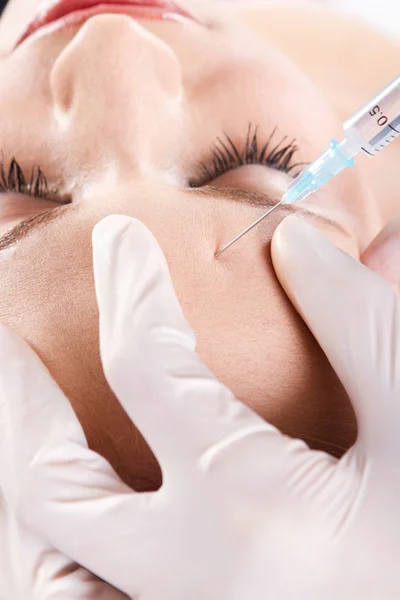 Médico dando uma injeção de botox na testa da mulher — Fotografia de Stock