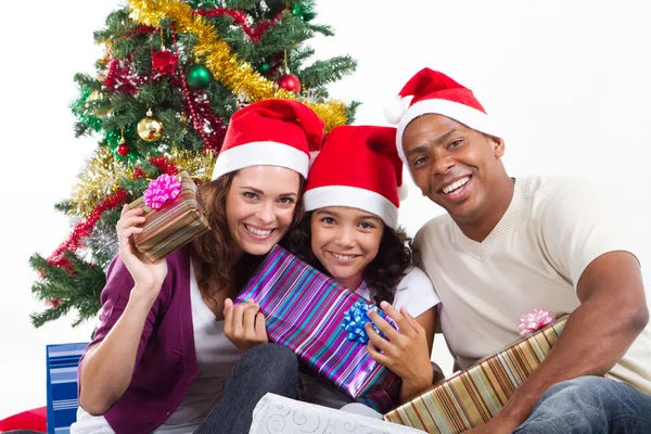 Gelukkig multiraciaal gezin met geschenken met Kerstmis Stockfoto