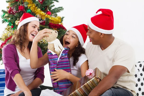 打开圣诞礼物在家里的幸福家庭 免版税图库图片
