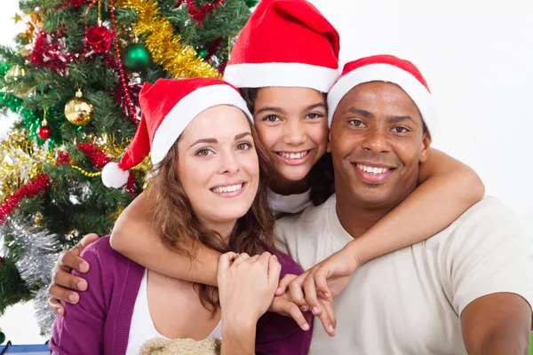幸福的一家人坐在圣诞树旁 图库照片