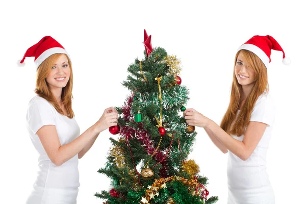 Happy teen sisters decorating Christmas tree Stock Picture