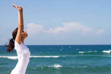 Kumsalda yoga yaparken sağlıklı genç bir kadın