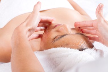 Woman receiving honey facial massage clipart