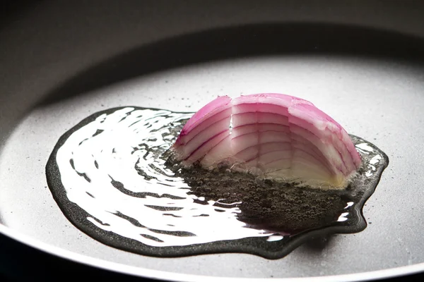 stock image Red onion cooking in frying pan with oil