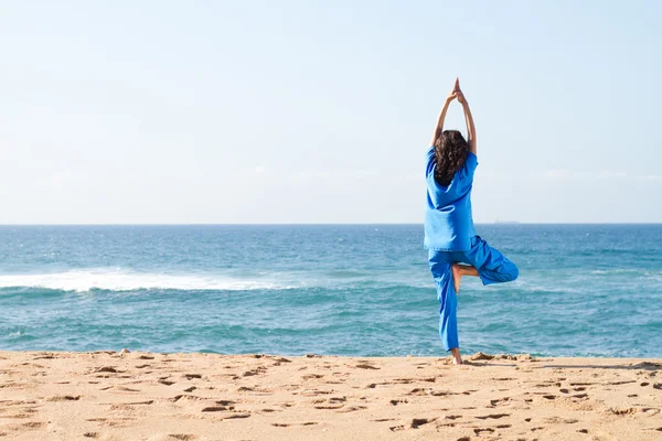 Молода жінка робить йогу на пляжі — стокове фото