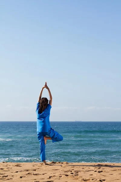 Jovem fazendo ioga na praia — Fotografia de Stock