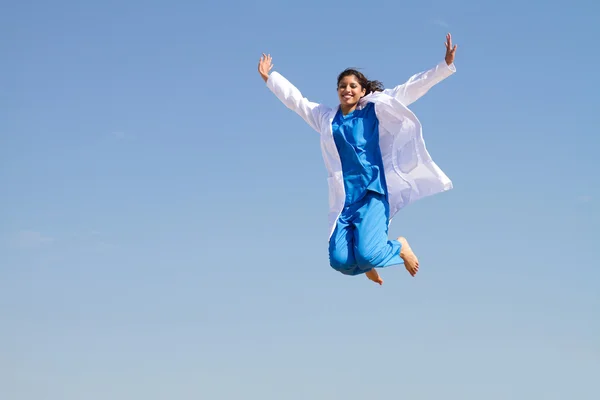 Cheerful young female doctor jumping high — Stock Photo, Image