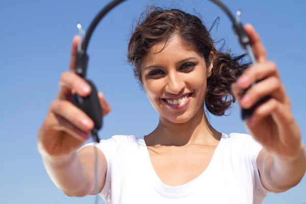Mulher jovem segurando fones de ouvido — Fotografia de Stock