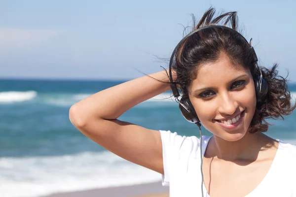 Jonge Arabische vrouw luisteren muziek op strand — Stockfoto