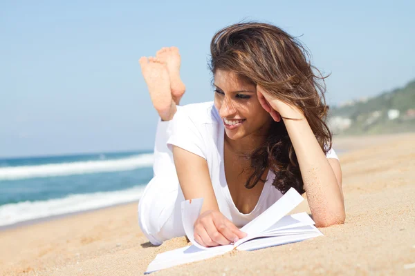 Young woman reading book on beach — Stock Photo, Image