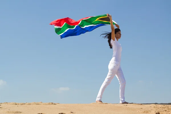 Jovem mulher segurando uma bandeira da África do Sul na praia — Fotografia de Stock