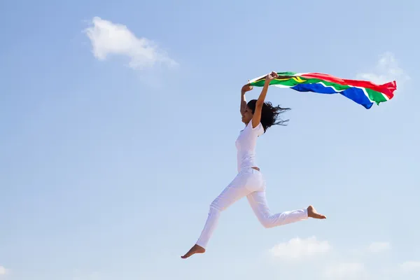Feliz joven con bandera sudafricana y saltando —  Fotos de Stock