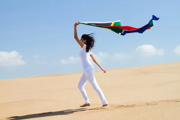 Mujer joven corriendo en la playa con bandera de Sudáfrica —  Fotos de Stock