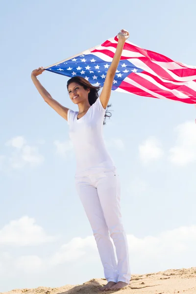 Ευτυχισμένη νέα γυναίκα που κρατά την αμερικανική σημαία — Φωτογραφία Αρχείου