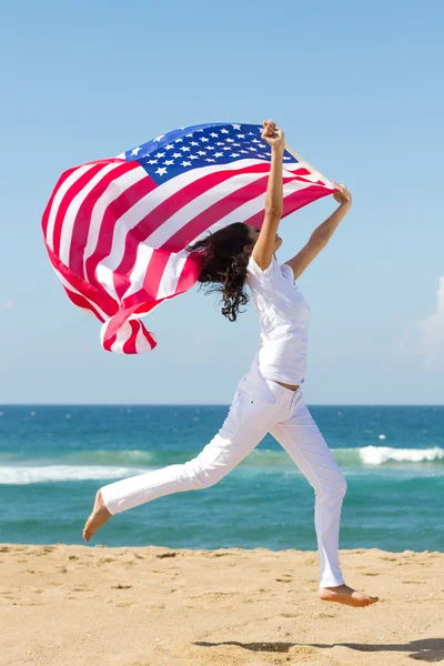 Νέα ενεργό γυναίκα που κρατά την αμερικανική σημαία — Φωτογραφία Αρχείου