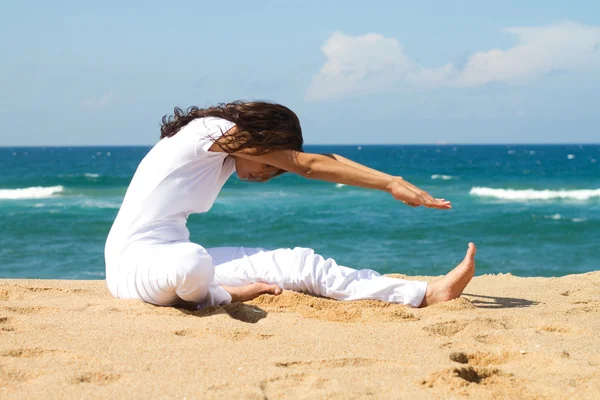 Молодая здоровая женщина занимается йогой на пляже — стоковое фото
