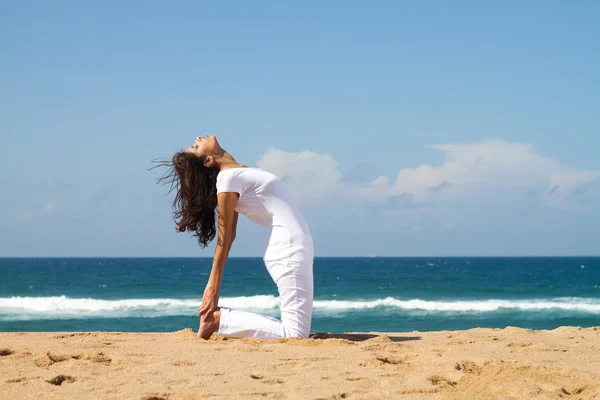 Junge gesunde Frau macht Yoga am Strand — Stockfoto