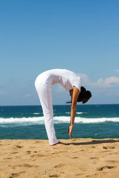 Junge gesunde Frau macht Yoga am Strand — Stockfoto