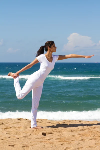 Mladá zdravá žena dělá jógu na pláži — Stock fotografie