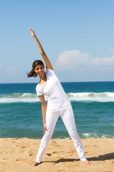Молодая здоровая женщина занимается йогой на пляже — стоковое фото