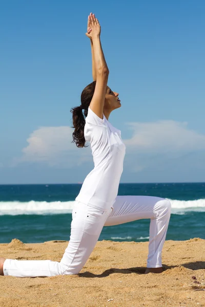 Žena dělá jógu na pláži — Stock fotografie