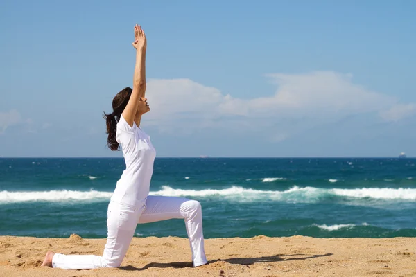 Jeune femme en bonne santé faisant du yoga sur la plage — Photo