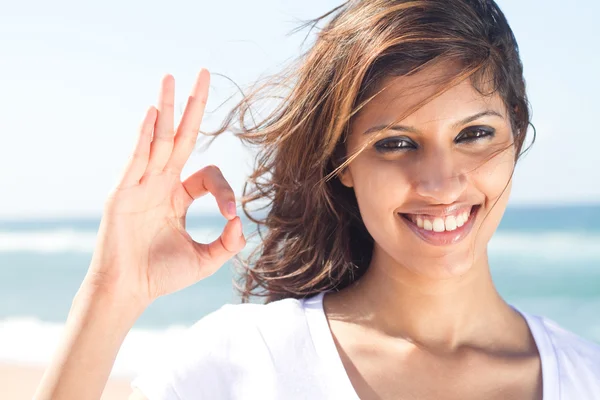Woman giving ok hand sign on beach — Stock Photo, Image