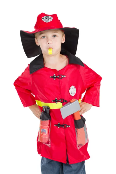 Pequeno menino bombeiro soprando seu apito — Fotografia de Stock