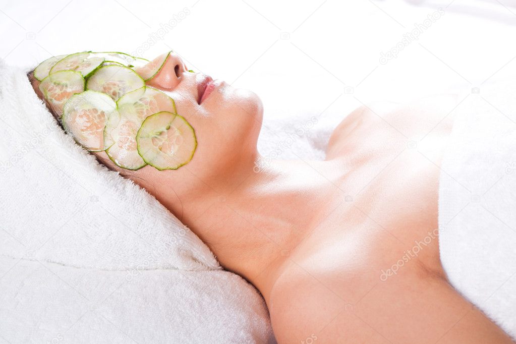 Asian woman with a facial cucumber mask on her face
