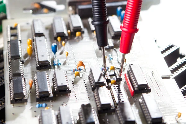 Multímetro testando uma placa de circuito — Fotografia de Stock