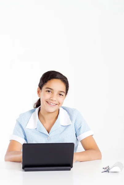 Bir dizüstü bilgisayar kullanarak okul üniformalı preteen kız — Stok fotoğraf