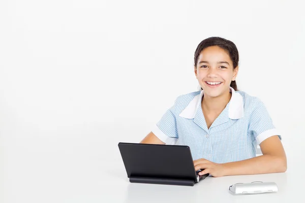 Preteen flicka i skoluniform som använder en bärbar dator — Stockfoto