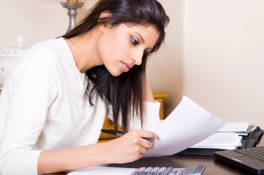 Beautiful woman doing finances at home clipart