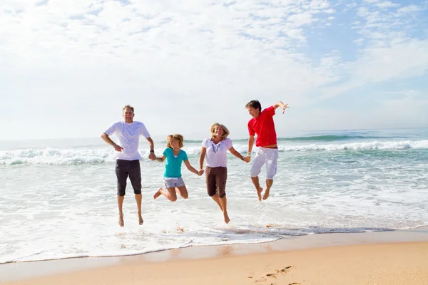 Familie springt am Strand — Stockfoto